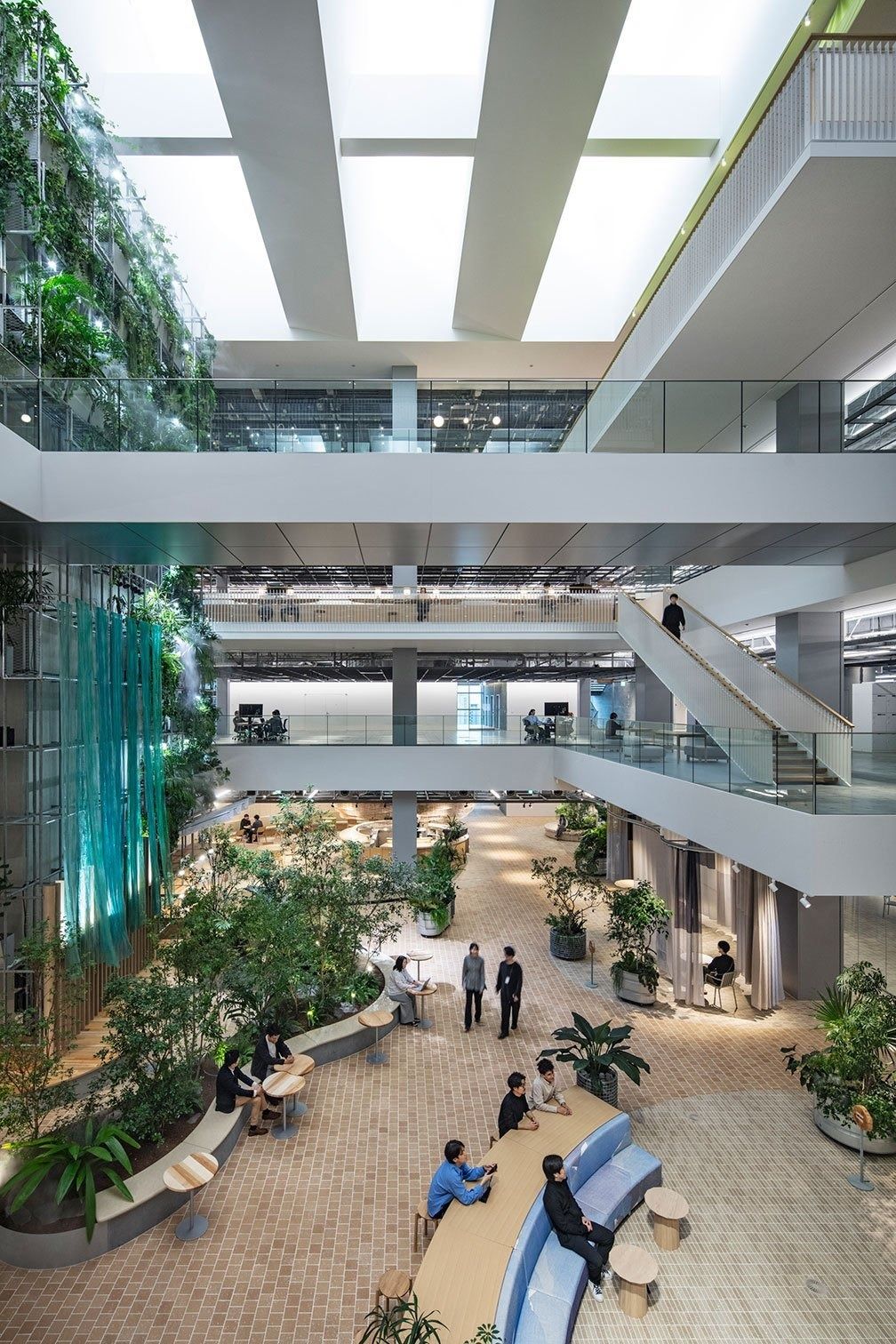 Panasonic: Tall atrium with plants and stairs, seen from an upper floor