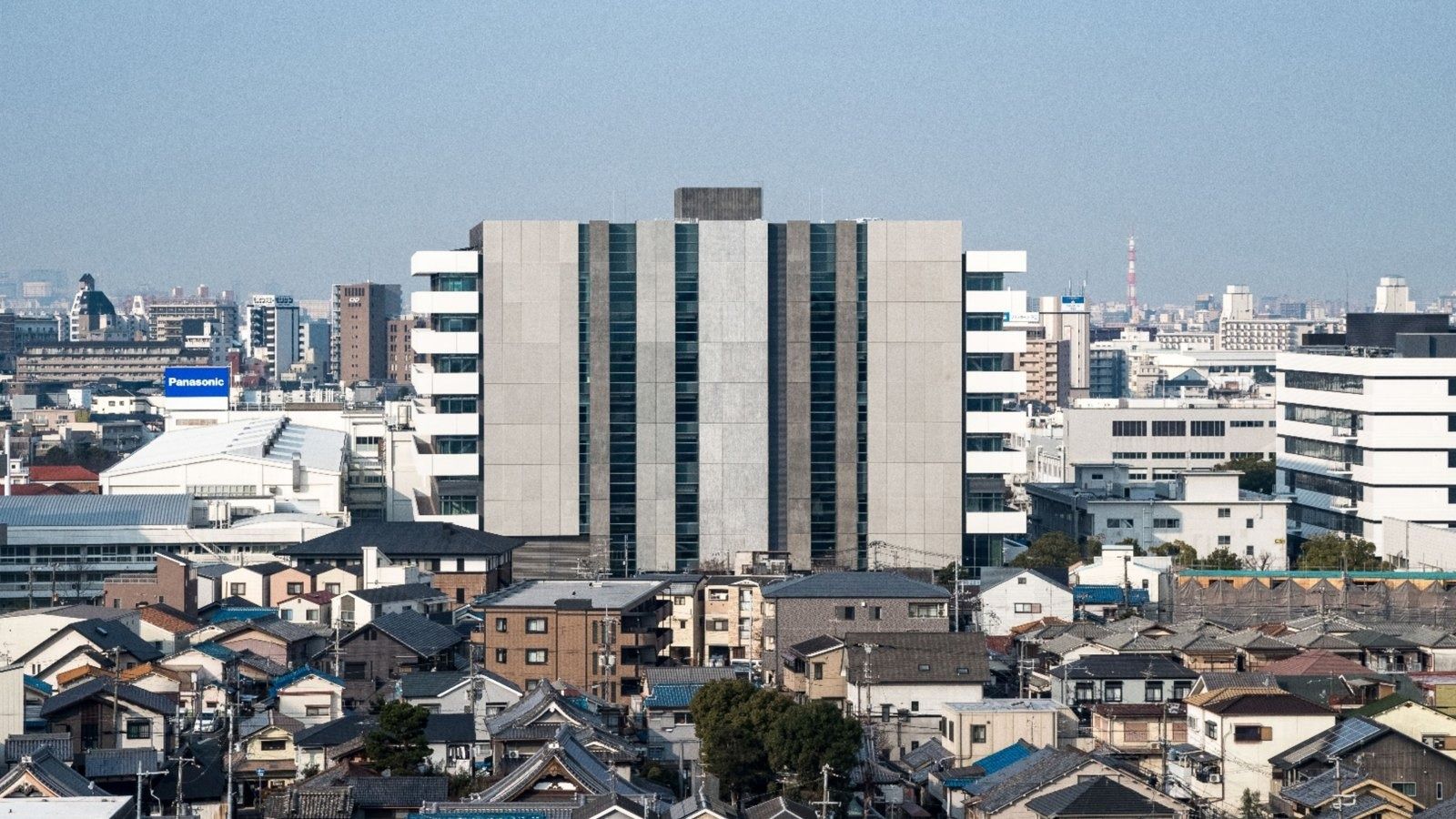 Panasonic: White building rising above houses and low buildings