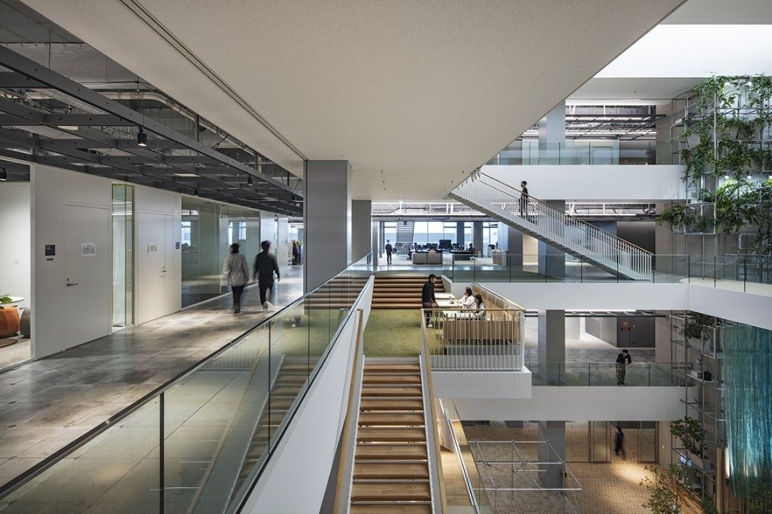 Panasonic: Wide timber stair between floors beside an open office