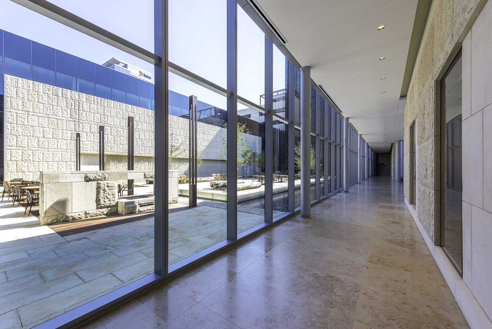 Phillips 66: A glass corridor beside a limestone courtyard