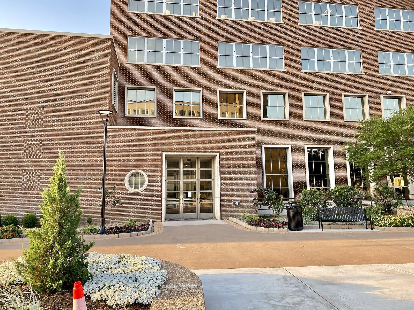 Entrance of a tall brick office building with a small garden