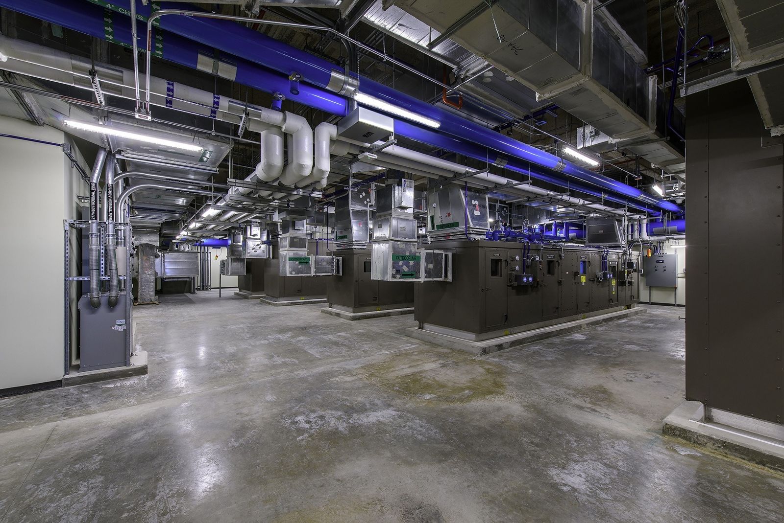 Phillips 66: Pipes and equipment in a large mechanical room lit in blue