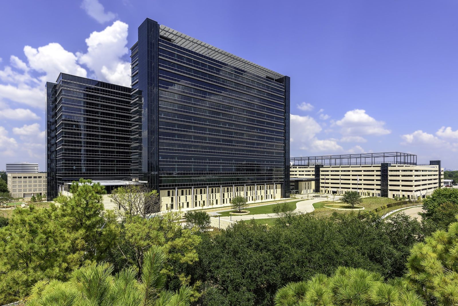 Phillips 66: Two dark glass towers above trees and a garden