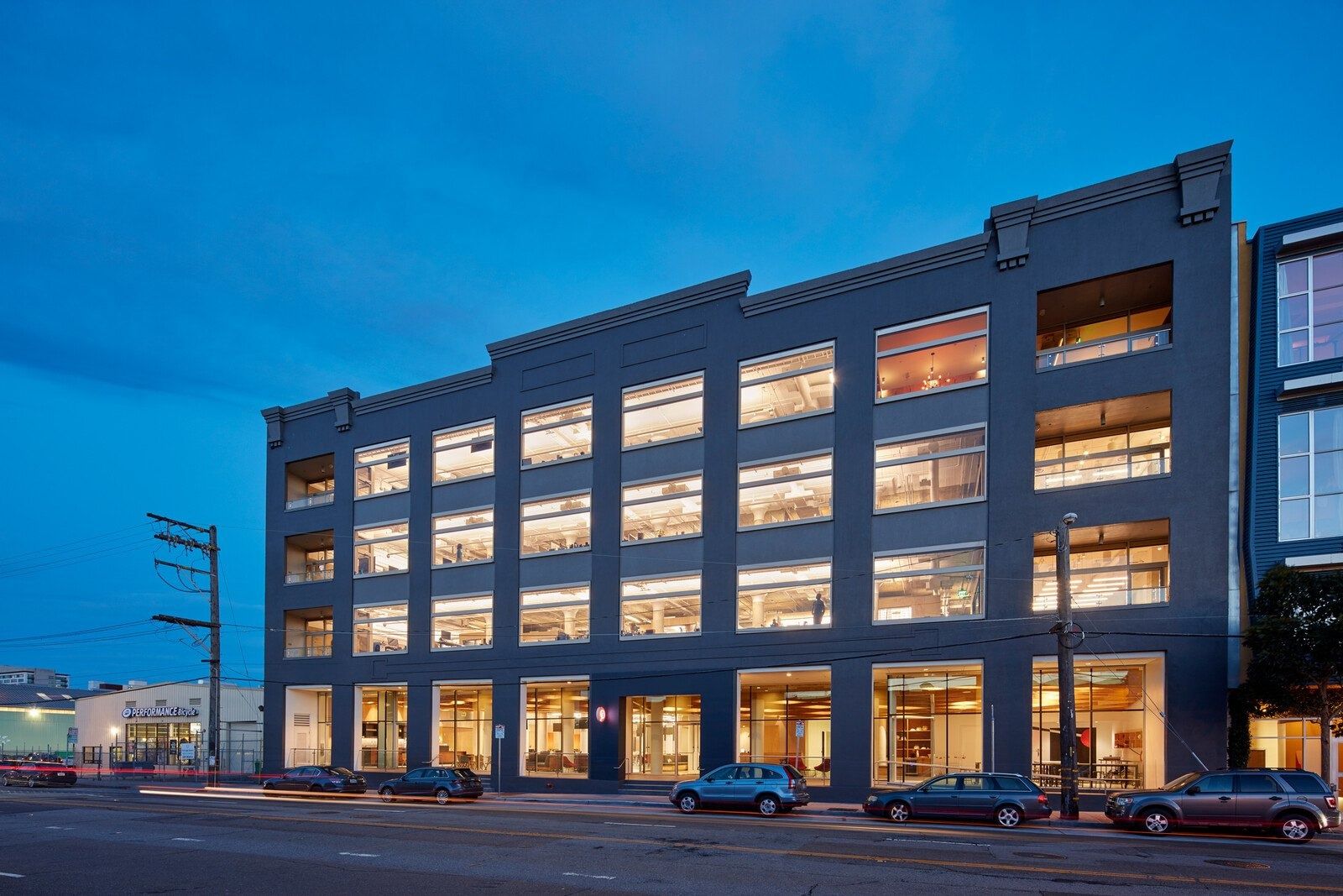 A five-storey industrial building lit at dusk
