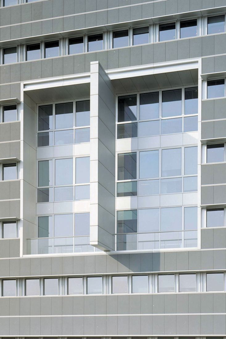 Pirelli: Close view of a stone-clad façade with a framed window bay