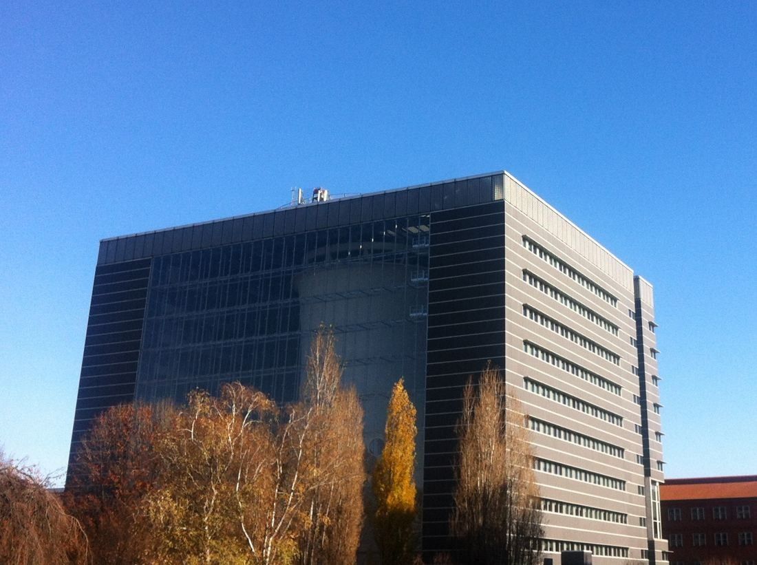 Pirelli: Dark glass and pale stone office block against a blue sky with autumn trees