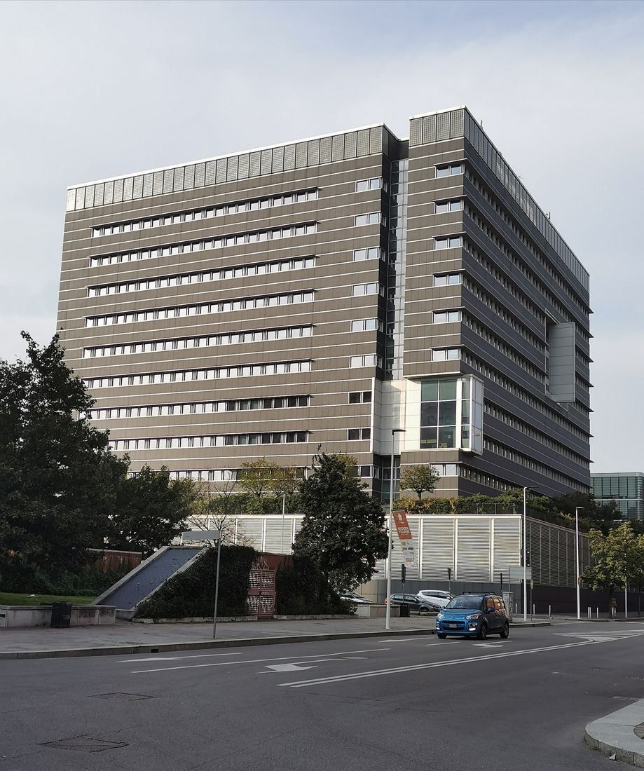 Pirelli: Grey stone-clad office building with horizontal window bands at a street corner