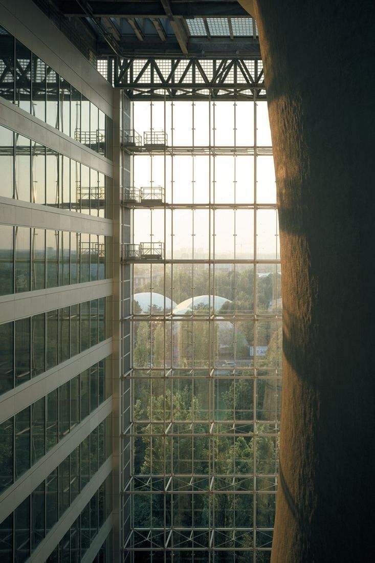 Pirelli: Narrow view between the glass façade and the rough curved surface of the cooling tower