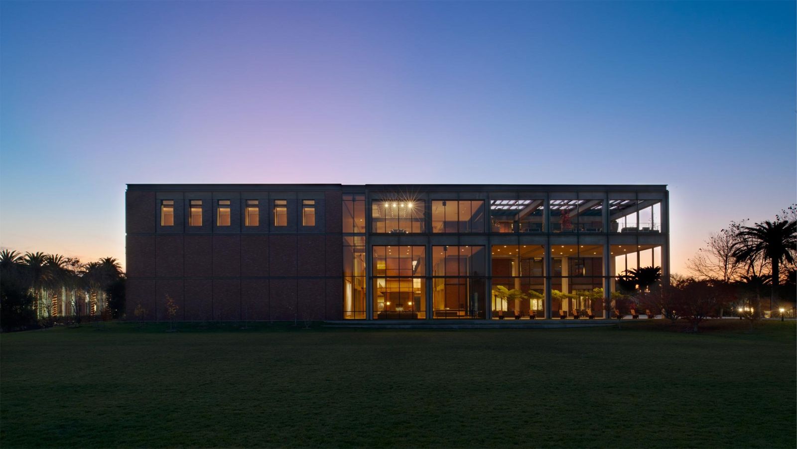 Pixar Animation Studios: Dark brick building with lit glass bays at dusk