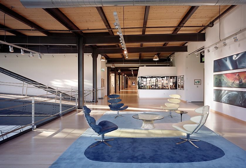 Pixar Animation Studios: Gallery space with blue lounge chairs and timber ceiling