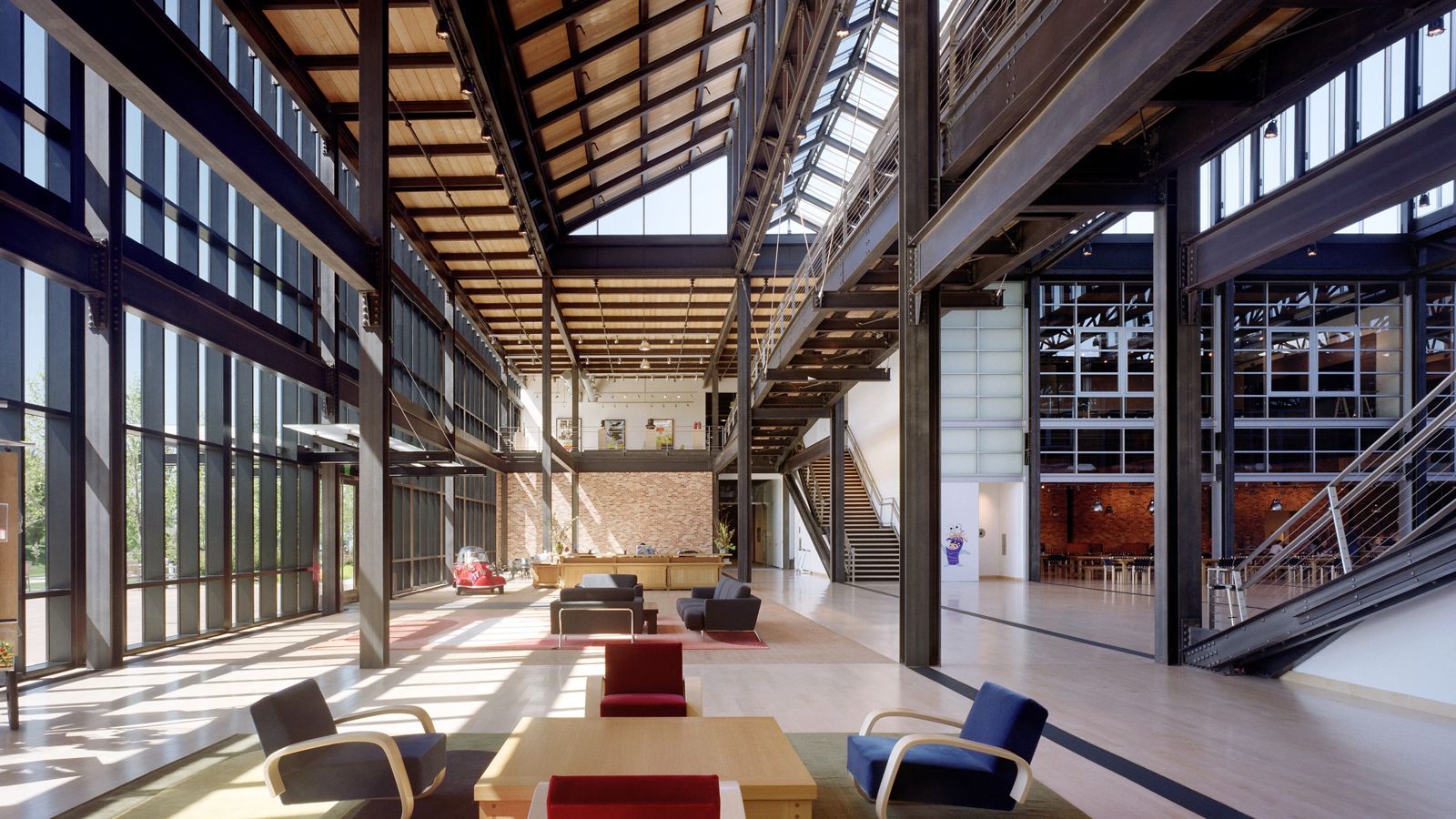 Pixar Animation Studios: Long atrium under a steel roof with sawtooth skylights and lounge chairs