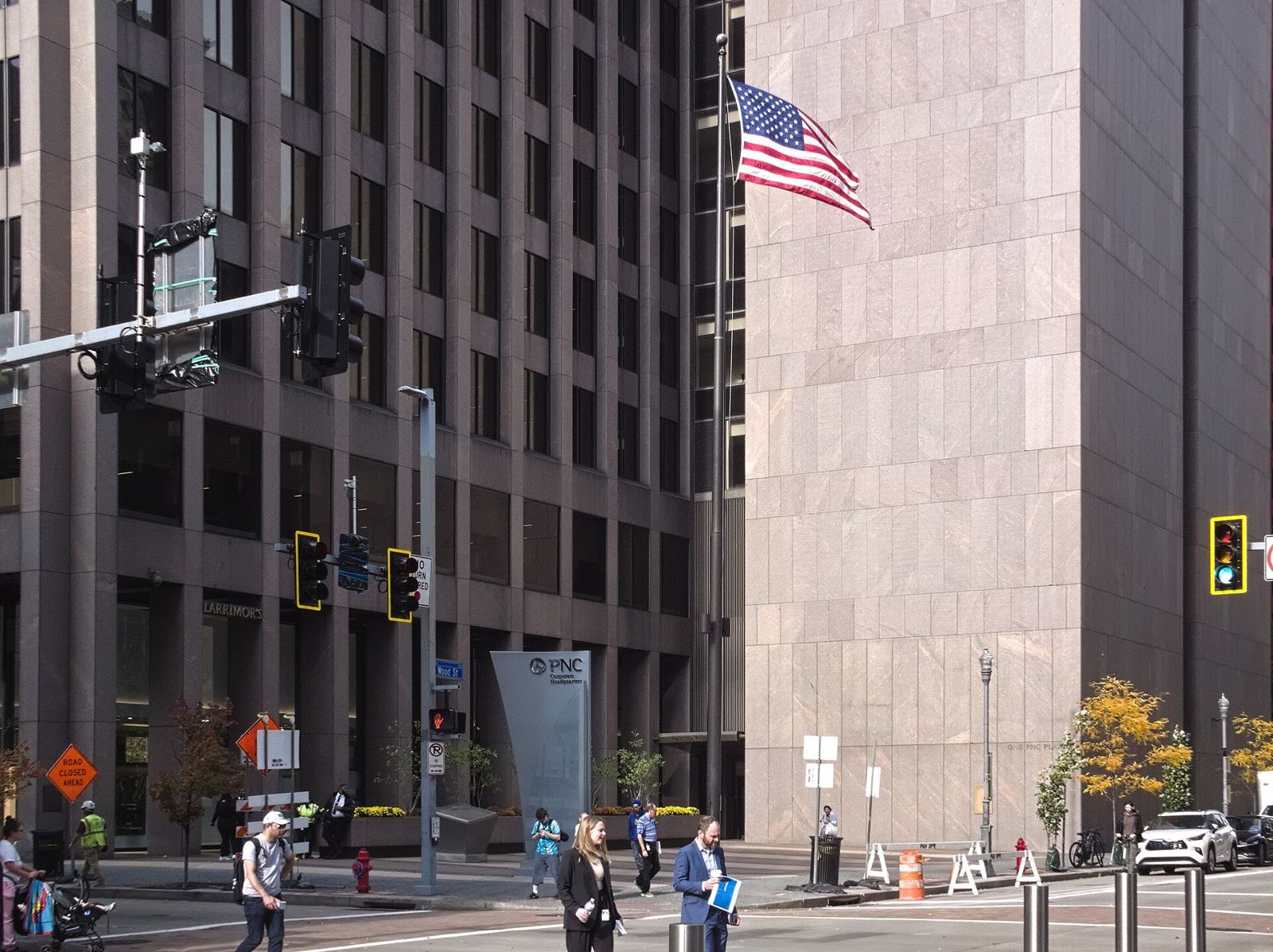 Granite-clad tower at a street corner with an American flag