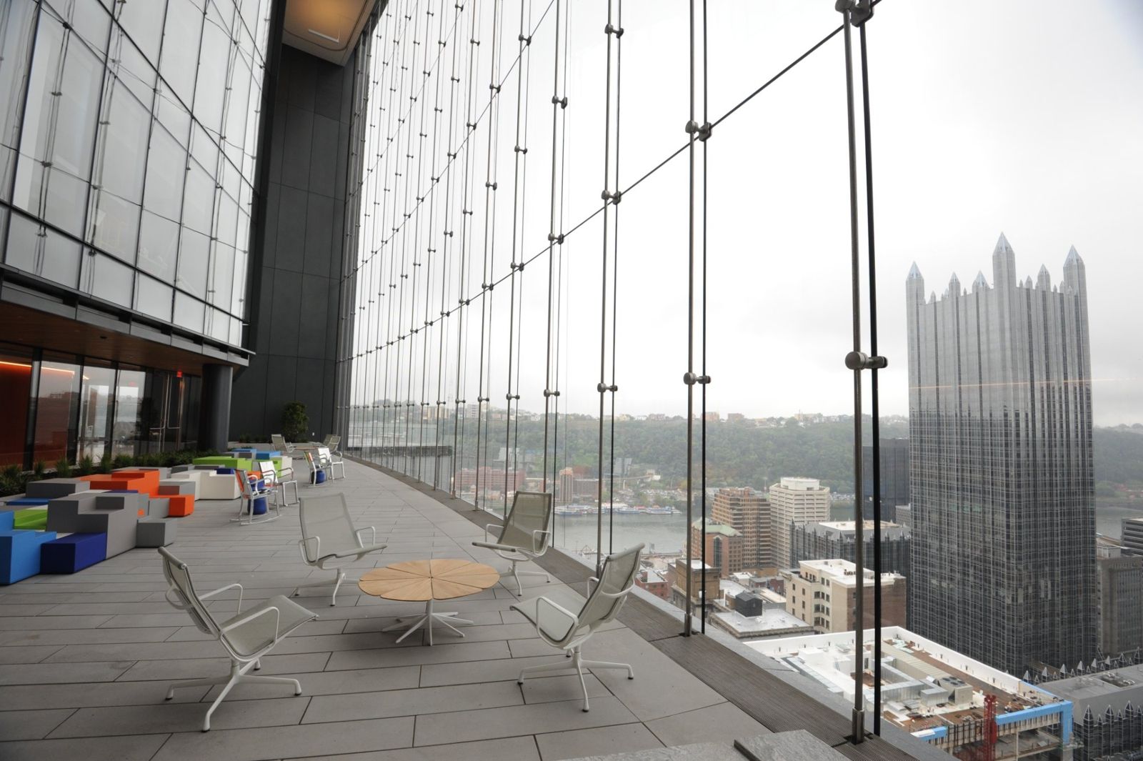 PNC Financial Services: Indoor park with lounge chairs behind a glass wall looking out on downtown