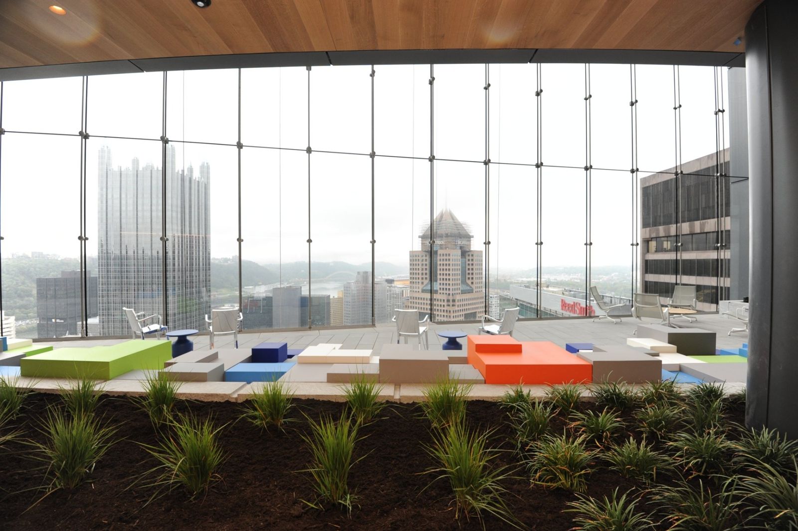 PNC Financial Services: Indoor park with planting beds and colorful seats in front of a glass wall