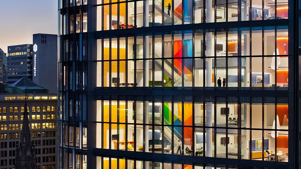 PNC Financial Services: Lit office floors with bright colors behind the glass at dusk