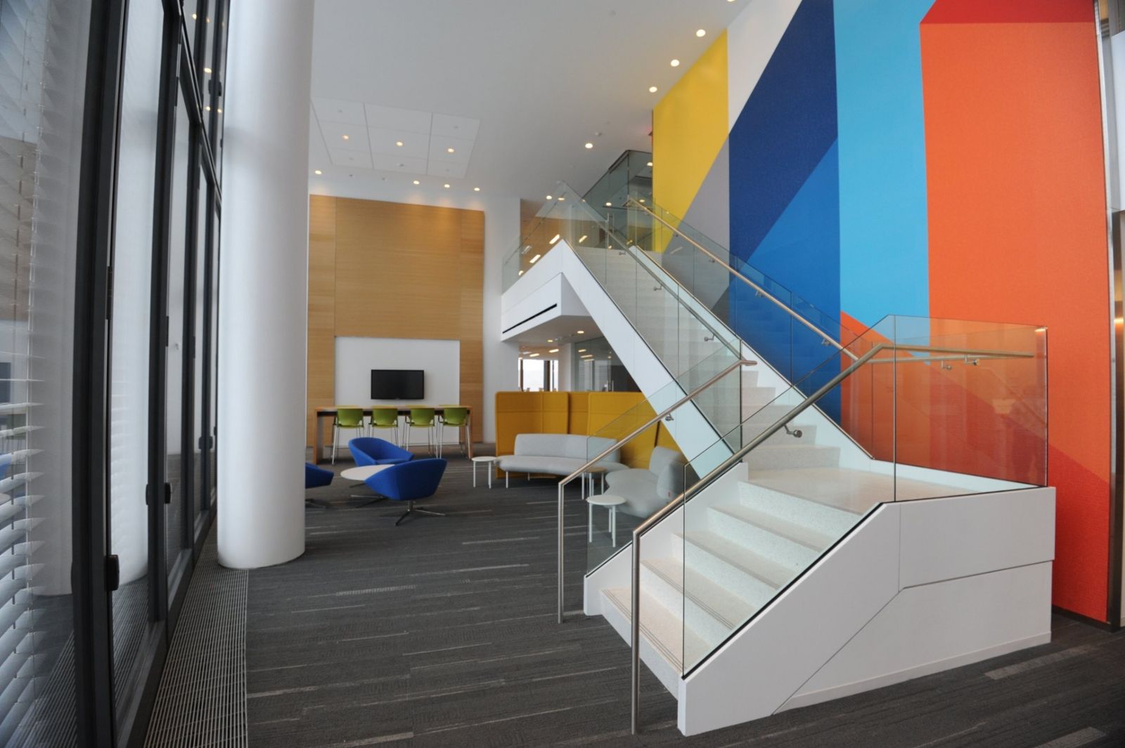 PNC Financial Services: Two-story workspace with a white stair and walls painted in blue, yellow and orange