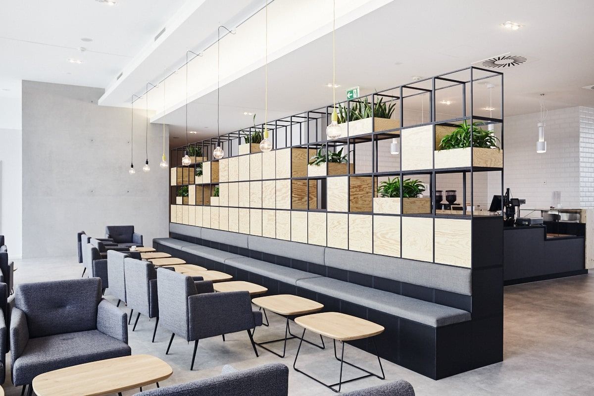 PUMA: Lounge seating along a wall of open shelving with plants