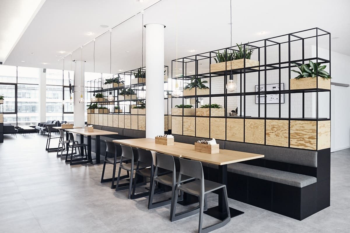 PUMA: Open office with long tables and black steel shelving with plants