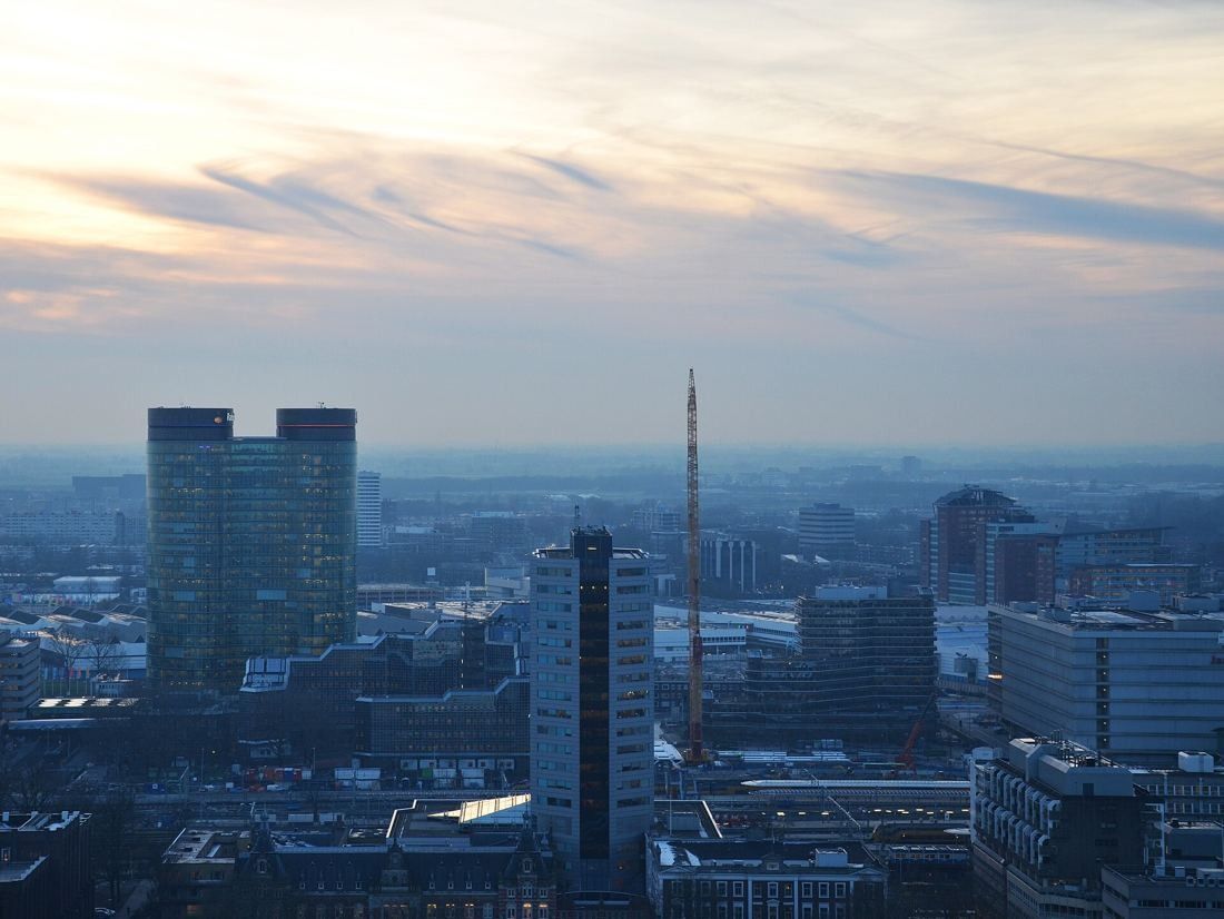 Rabobank: Aerial view over Utrecht's station area at dusk with the two towers on the left