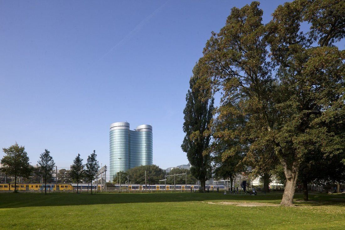 Rabobank: The two towers in the distance across a park lawn with large trees