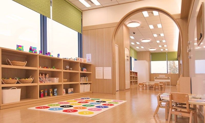 Rakuten Group: Daycare room with wooden shelves, an arched doorway and play mat