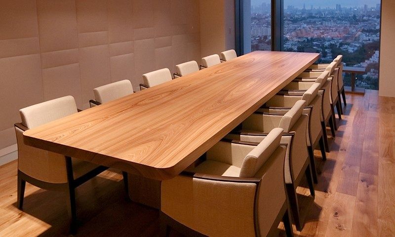 Rakuten Group: Long timber table with chairs by a window over the city