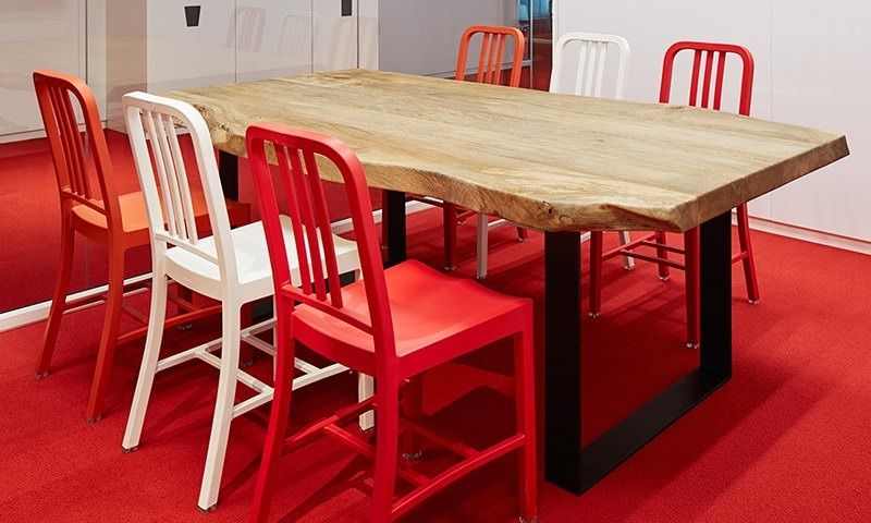 Rakuten Group: Meeting room with a live-edge wooden table, red and white chairs and red carpet