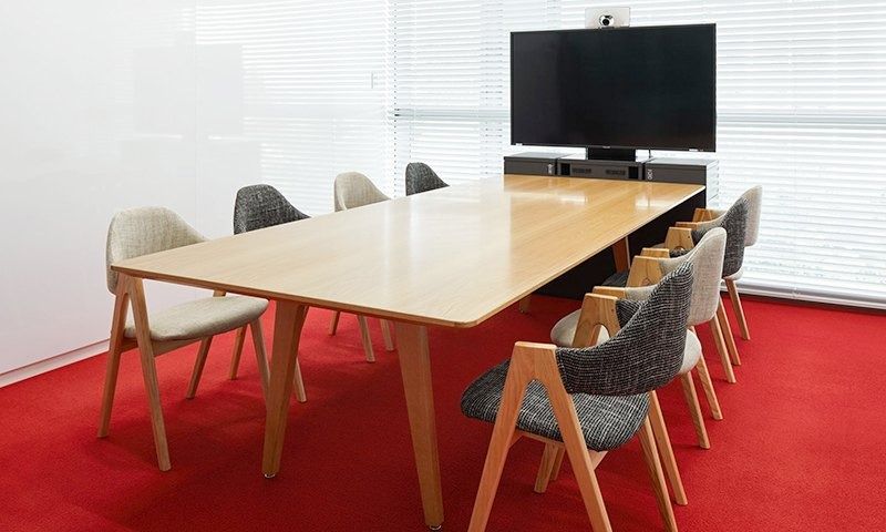 Rakuten Group: Meeting room with a long wooden table and grey upholstered chairs