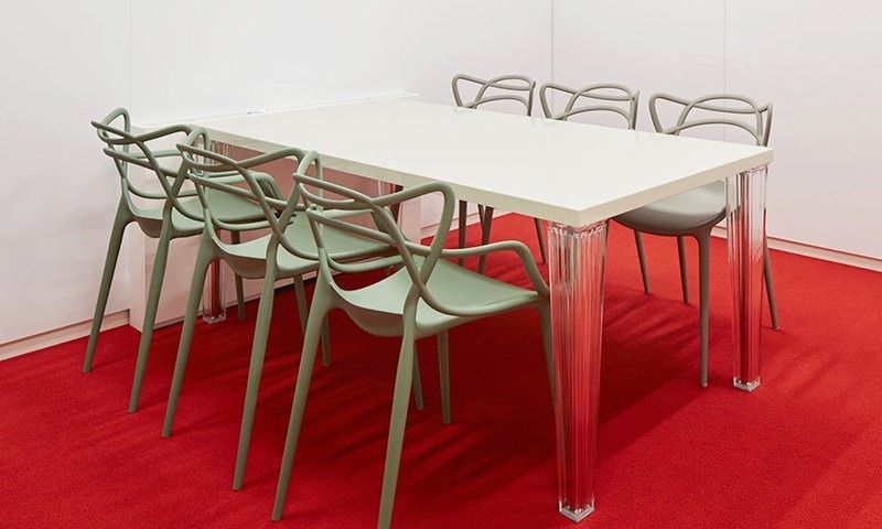 Rakuten Group: White table with sage green chairs on red carpet