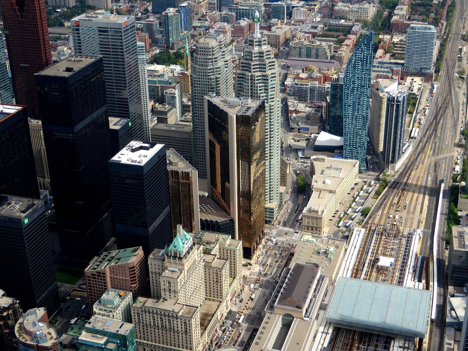 RBC (Royal Bank of Canada): Aerial view of downtown with gold towers next to rail tracks