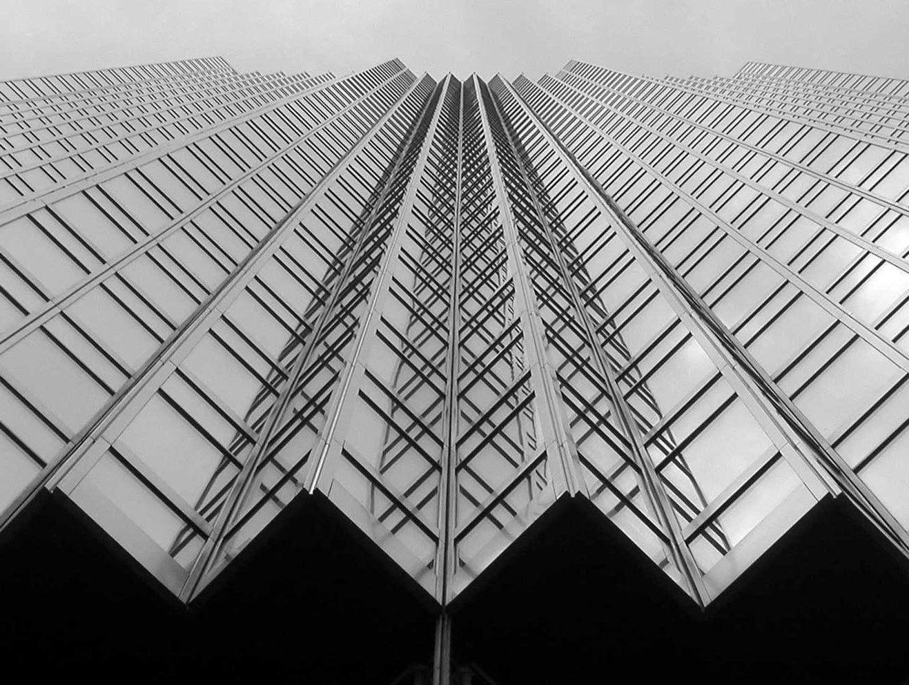 RBC (Royal Bank of Canada): Black-and-white upward view of a sawtooth glass facade