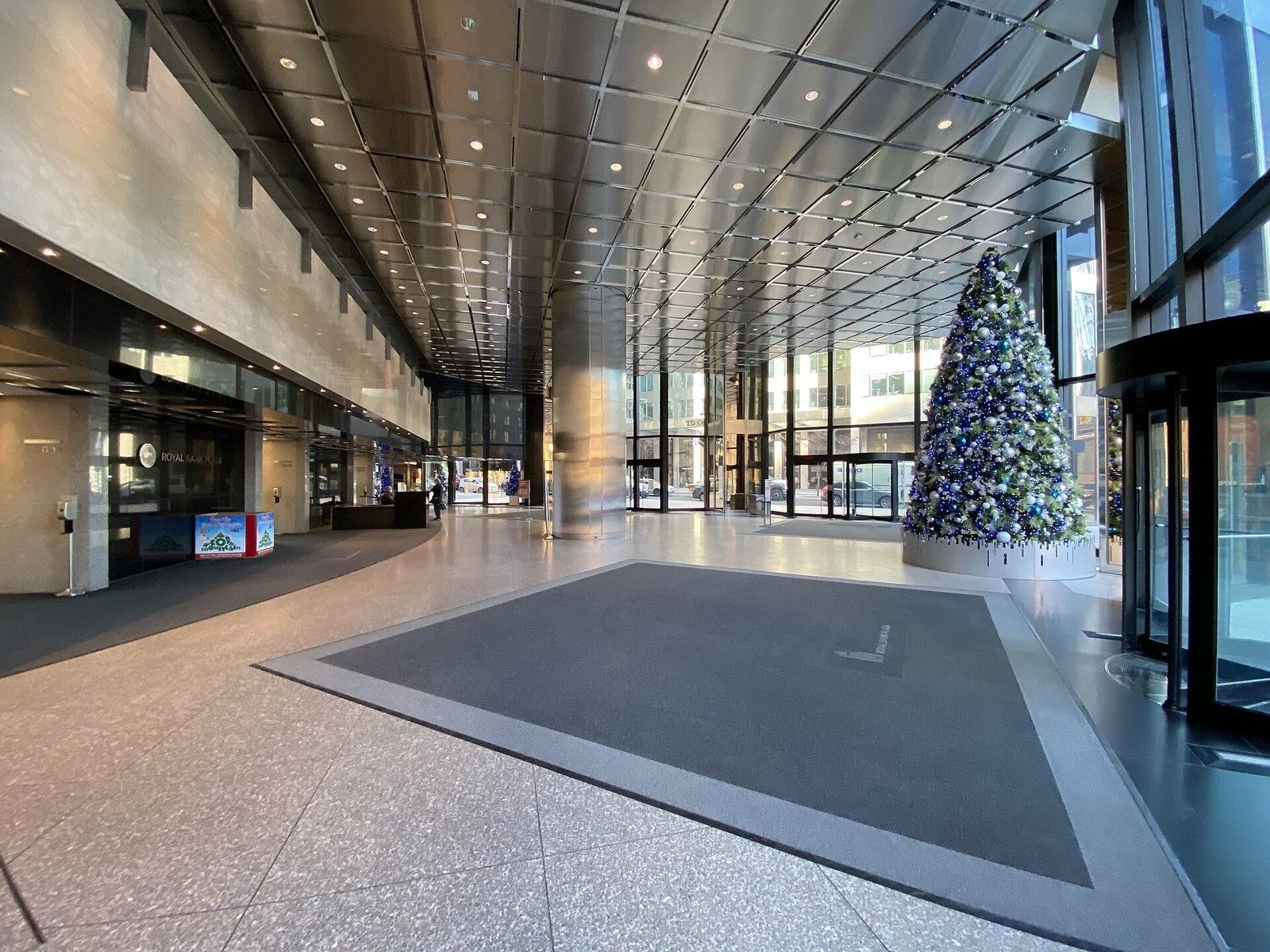 RBC (Royal Bank of Canada): Empty office lobby with stone floor, revolving doors and a Christmas tree