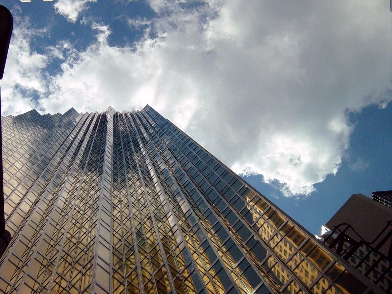RBC (Royal Bank of Canada): Gold glass facade seen from below against a cloudy sky