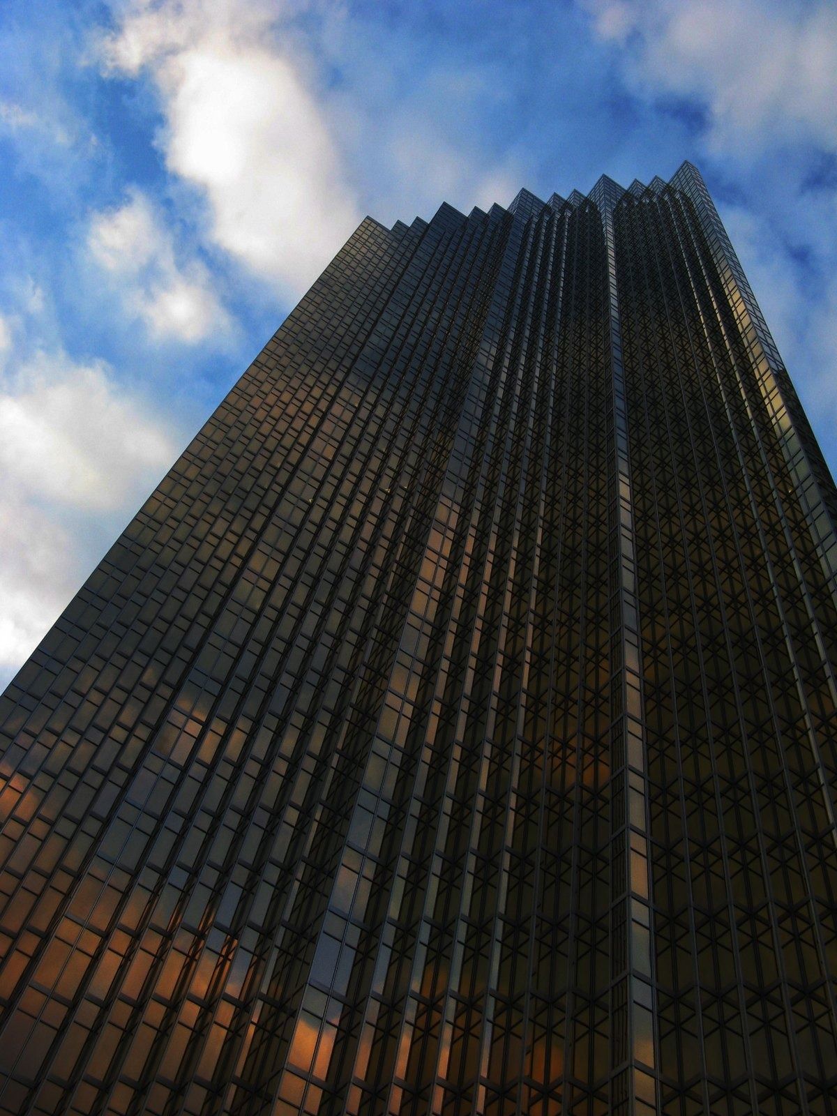 RBC (Royal Bank of Canada): Gold glass tower seen from below with clouds