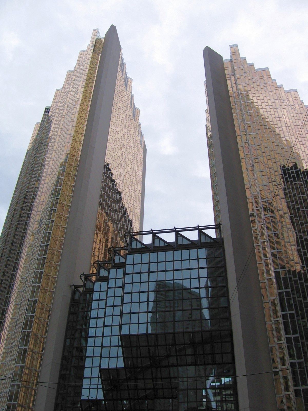 RBC (Royal Bank of Canada): Two gold towers with a dark glass atrium between them, seen from below
