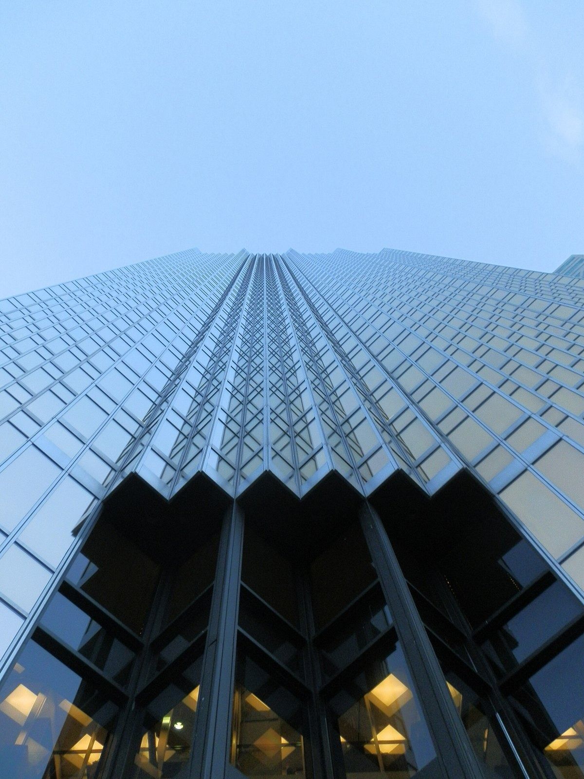 RBC (Royal Bank of Canada): Upward view of a folded gold glass facade against blue sky