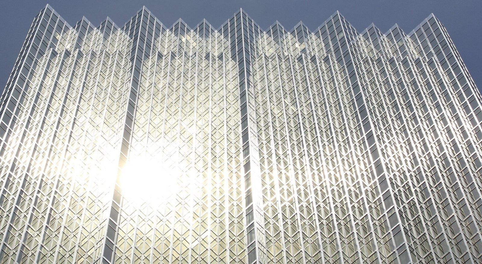 RBC (Royal Bank of Canada): Wide view of a sunlit gold glass facade with sawtooth folds