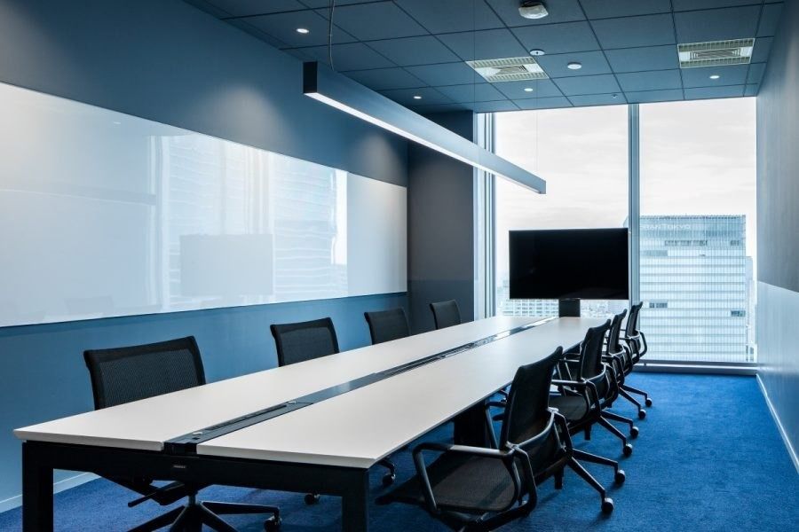 Recruit Holdings: Blue meeting room with a long white table and screen