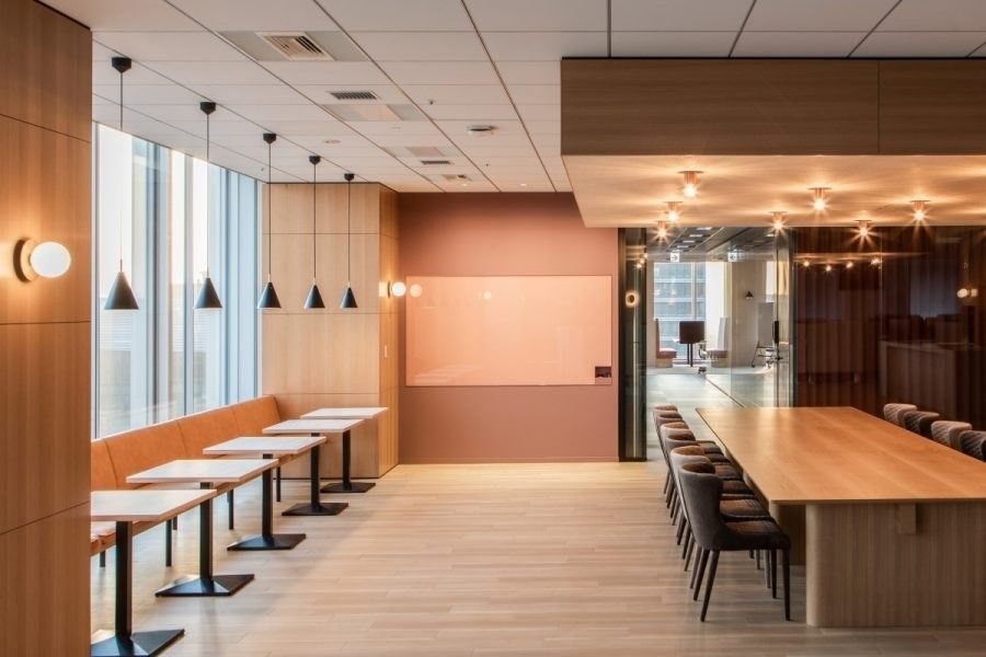 Recruit Holdings: Long room with a pink banquette, small tables and a big wooden table