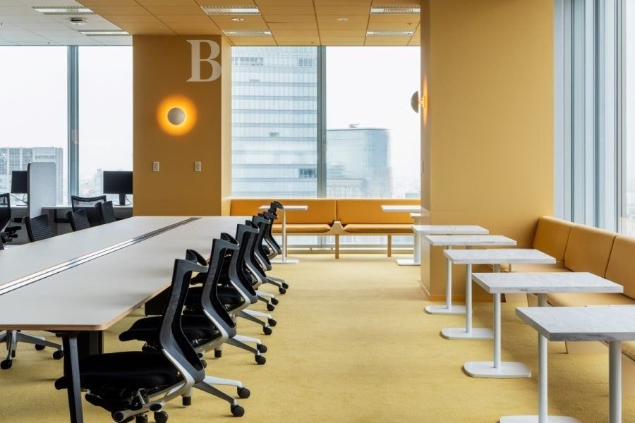 Recruit Holdings: Yellow-walled area with desks and banquettes