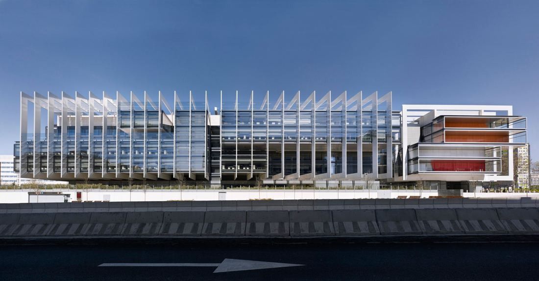 Repsol: Full length of the finned glass building seen from across a road