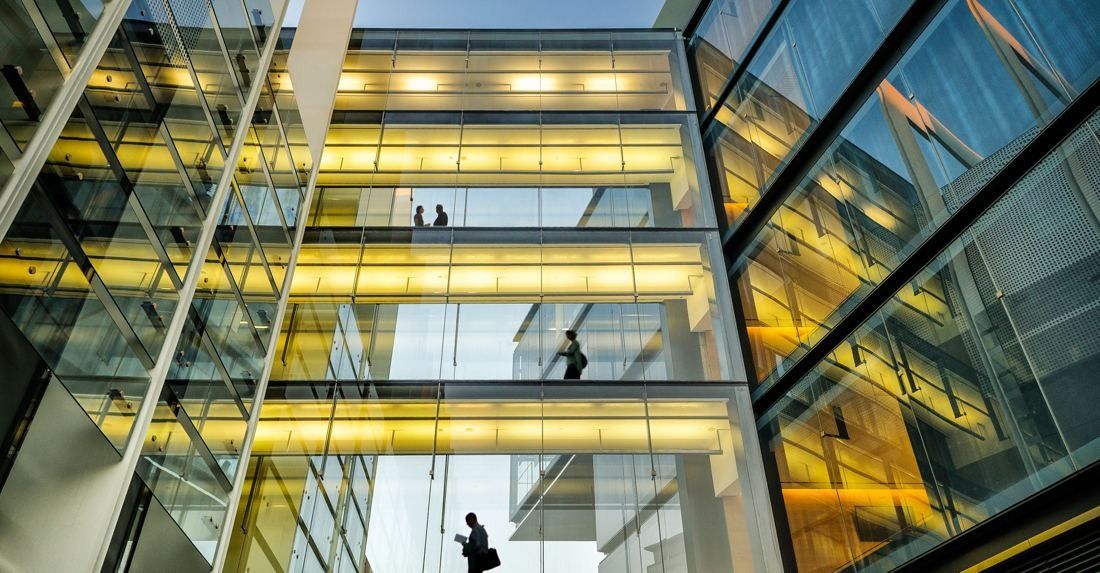 Repsol: Looking up through a glass atrium with lit floors and footbridges