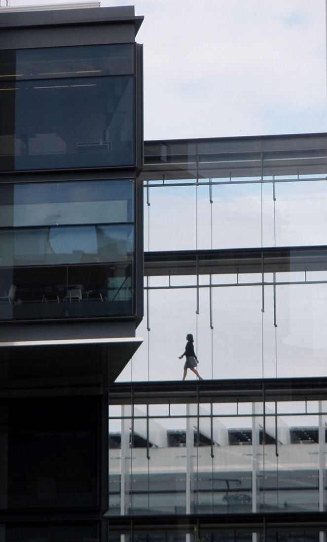 Repsol: Narrow glass bridge between two buildings with a small distant figure