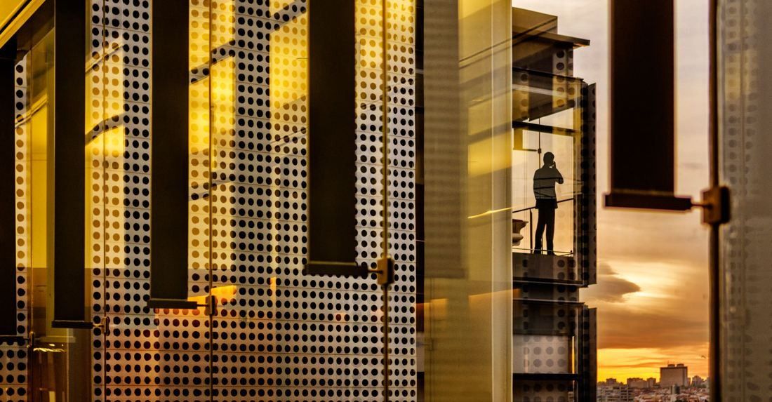 Repsol: Perforated metal panels and glass glowing gold at sunset