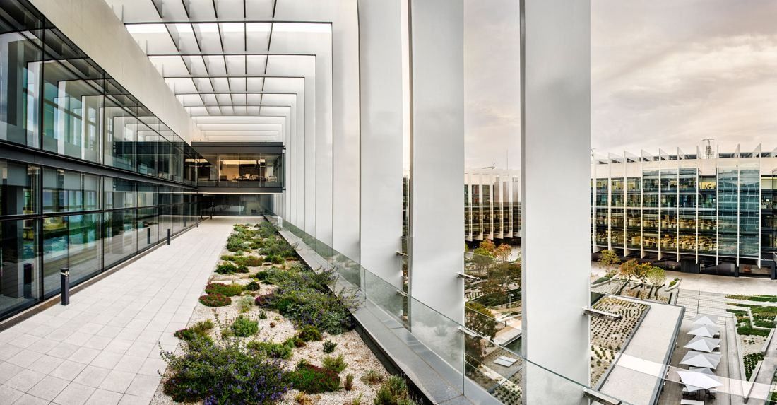 Repsol: Terrace between tall white fins and a glass façade, overlooking the garden