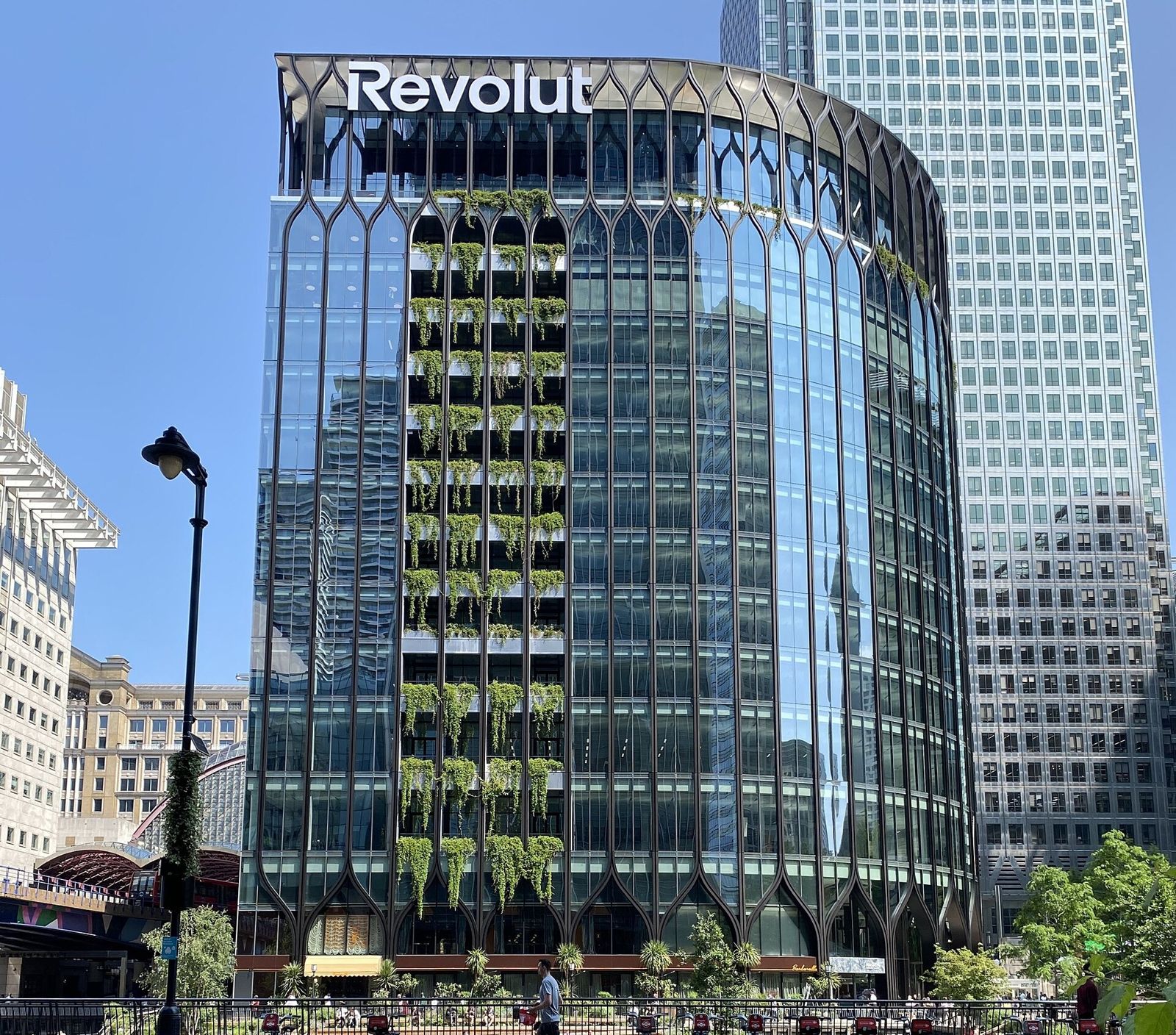 Revolut: Glass tower with a Revolut sign and planted facade