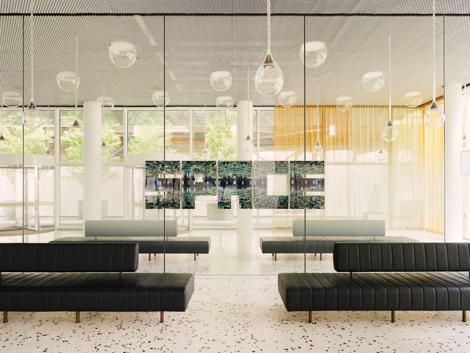 Roche: Bright lobby with black benches and glass walls