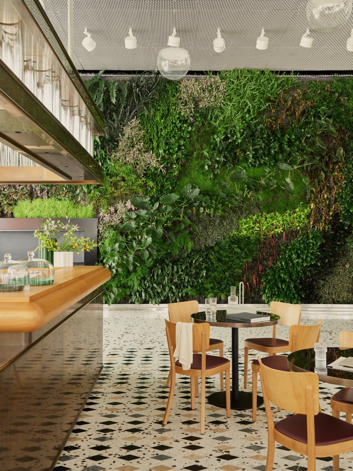 Roche: Café tables beside a green plant wall