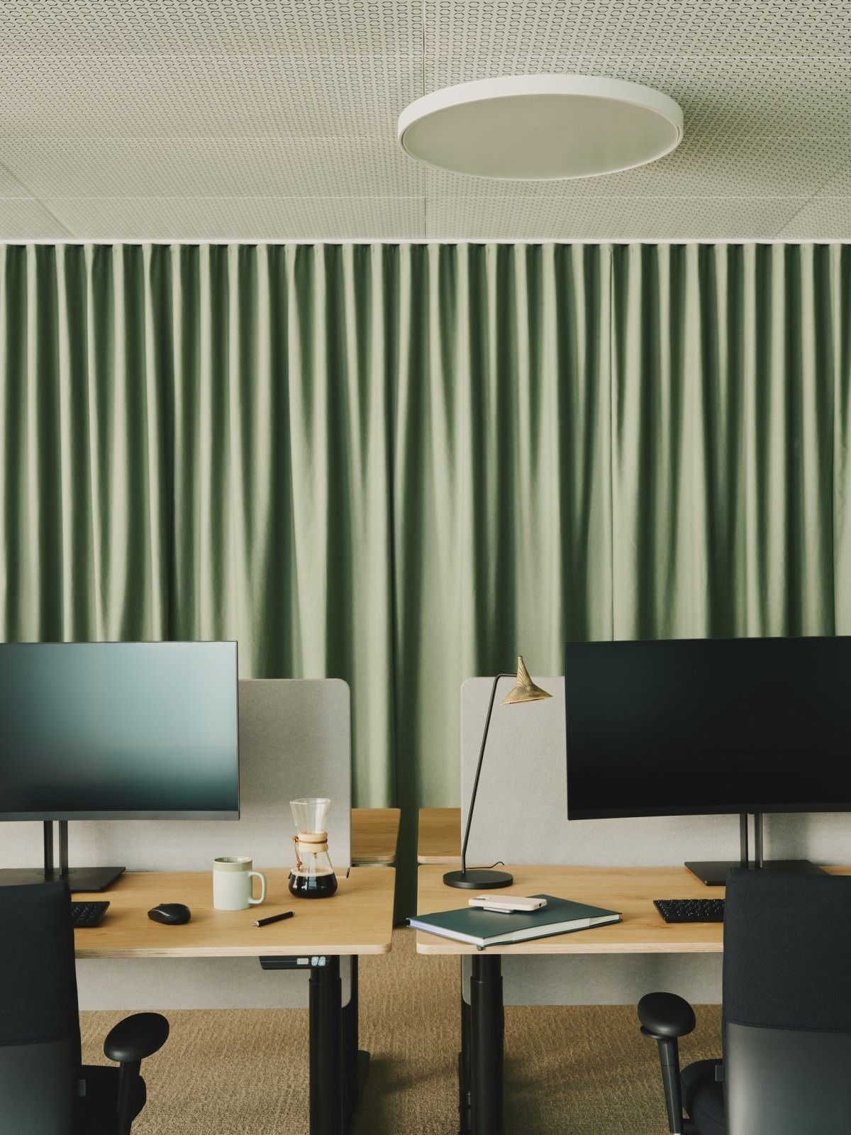 Roche: Desks with monitors in front of a green curtain