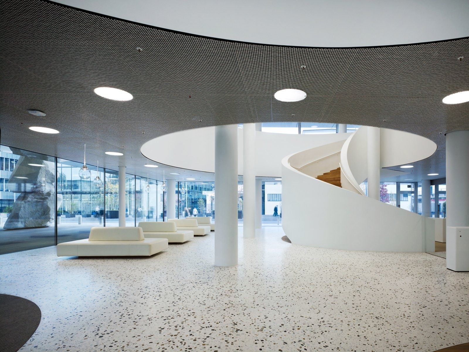 Roche: Round lounge with white benches around a spiral stair